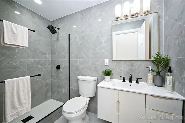 a bathroom with a sink a toilet a mirror and shower