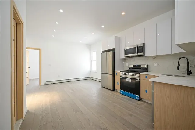 a kitchen with granite countertop a refrigerator and a stove top oven