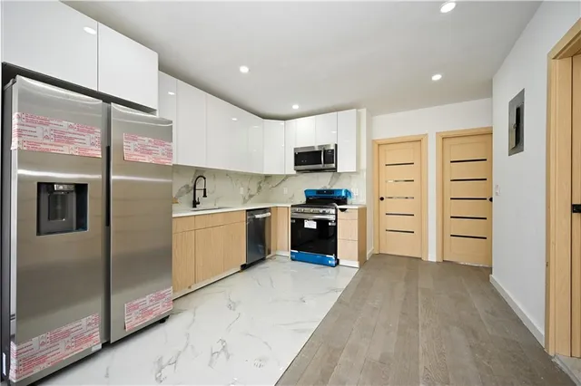 a kitchen with stainless steel appliances a refrigerator and a stove top oven