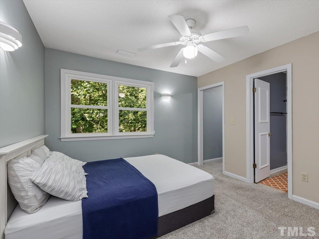 115 Inverness Court Cary, NC 27511 - Photo 18 of 25 a bedroom with a large bed and a chandelier