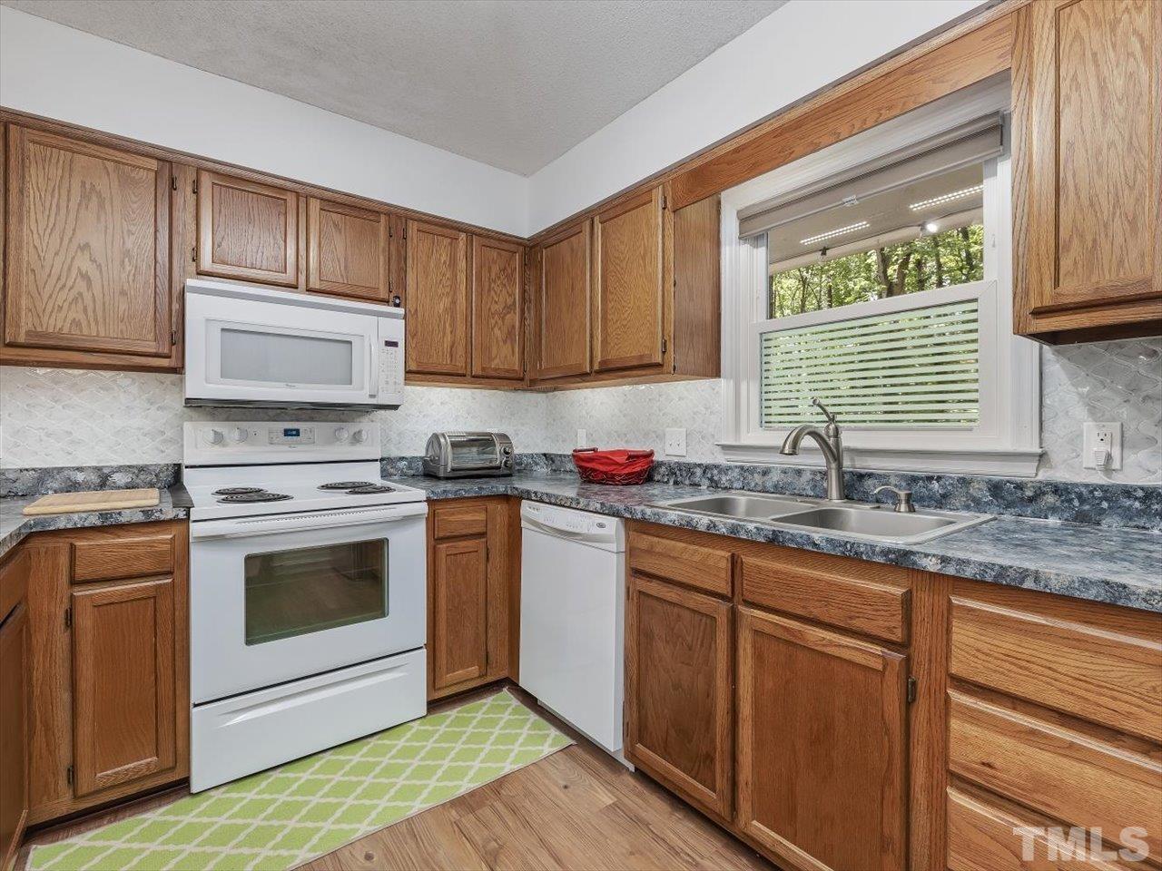 115 Inverness Court Cary, NC 27511 - Photo 7 of 25 a kitchen with stainless steel appliances granite countertop a sink a stove and cabinets