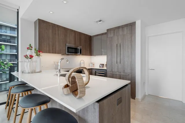 a kitchen with a sink a stove and chairs