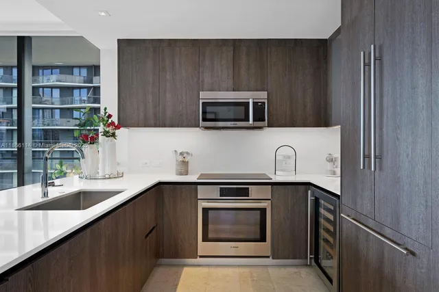 a kitchen with stainless steel appliances a stove microwave and sink