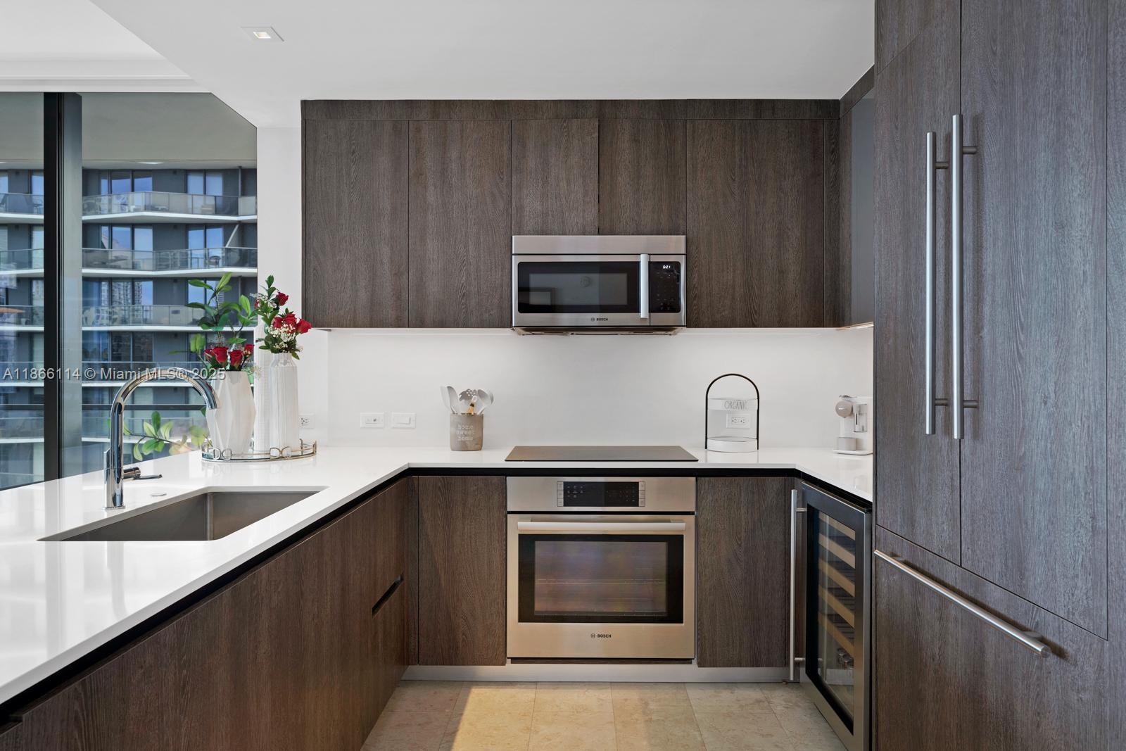 88 Southwest 7th Street, Unit 1401 Miami, FL 33130 - Photo 8 of 35 a kitchen with stainless steel appliances a stove microwave and sink