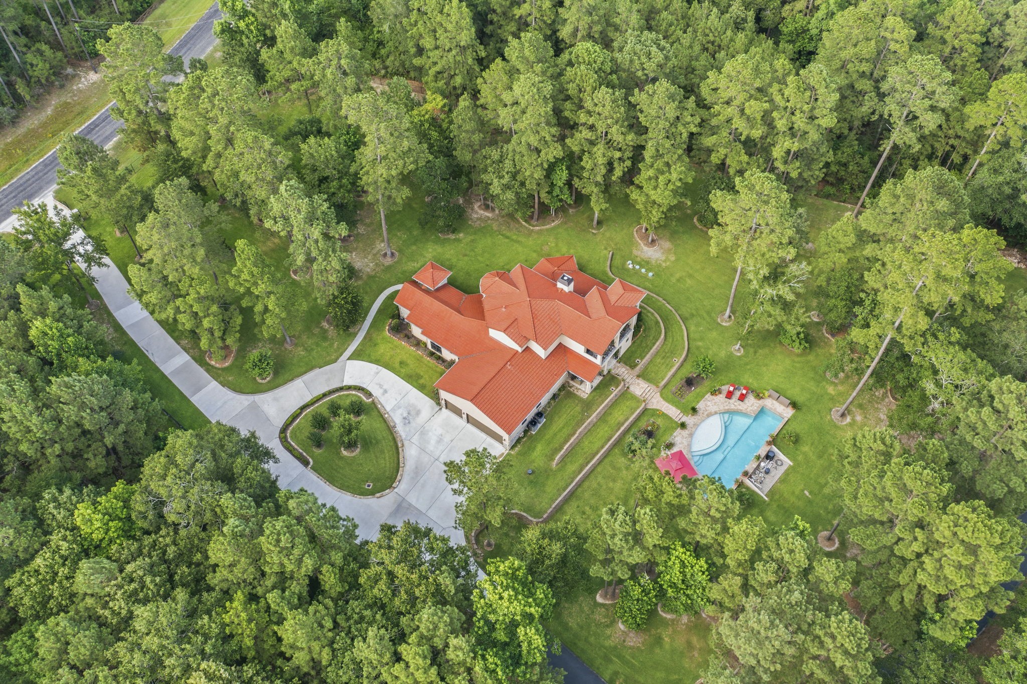 280 Sundog Road Huntsville, TX 77340 - Photo 6 of 50 Aerial view showcasing the home, circular driveway, and drive leading to the workshop, surrounded by the natural beauty of the wooded acreage.