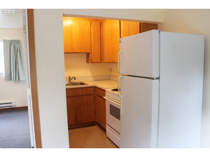 848 N Street Springfield, OR 97477 - Photo 12 of 33 a kitchen with a refrigerator a stove and a wooden floor