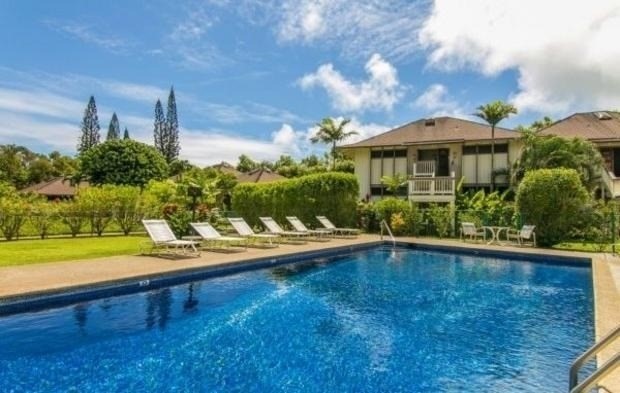 4480 Ka Haku Road, Unit 208 Princeville, HI 96722 - Photo 9 of 28 a view of a swimming pool with lawn chairs under an umbrella