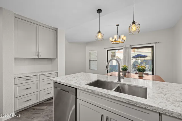 a kitchen view with granite countertop a sink a counter space appliances and cabinets