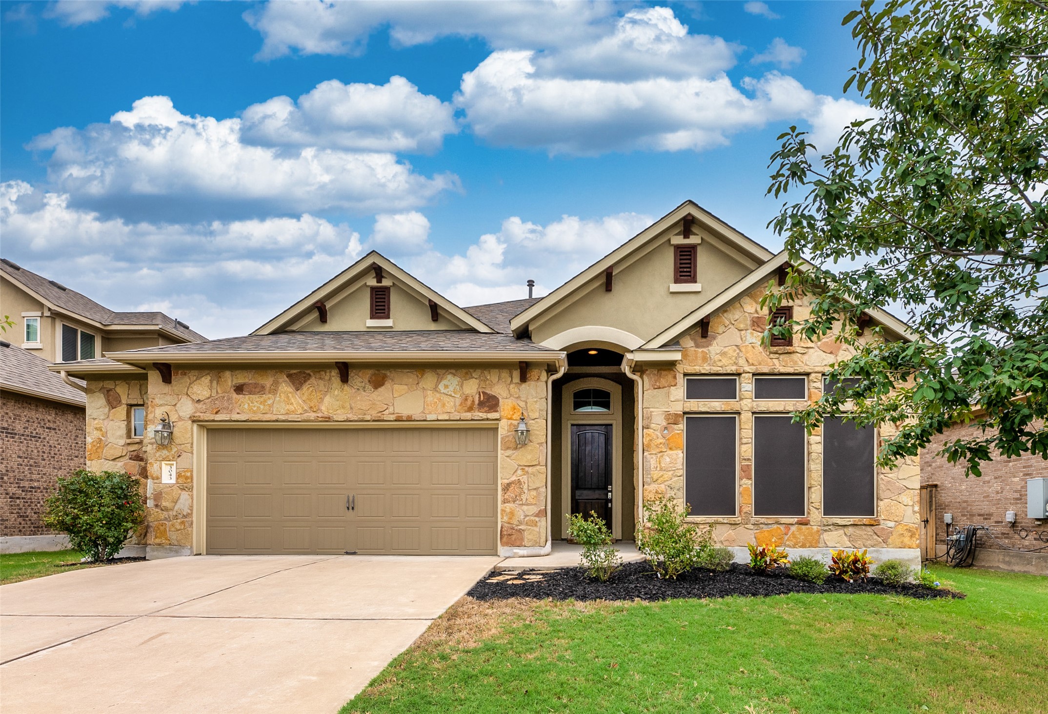 3043 Hidalgo Loop Round Rock, TX 78665 - Photo 1 of 34 View of front of property with stone siding, an attached garage, concrete driveway, a front lawn, and stucco siding