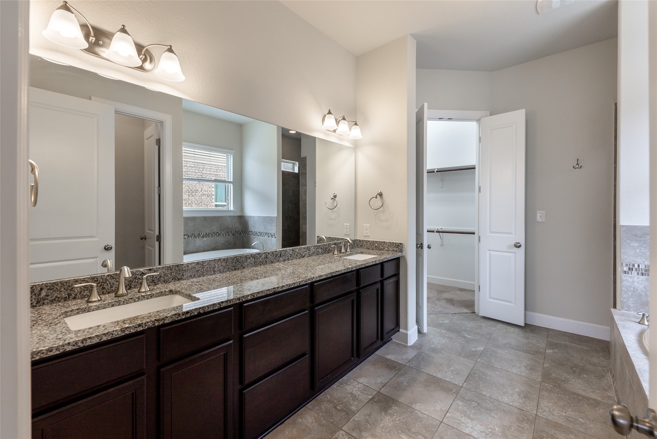 3043 Hidalgo Loop Round Rock, TX 78665 - Photo 12 of 34 Full bath featuring a bath, double vanity, and a walk in closet