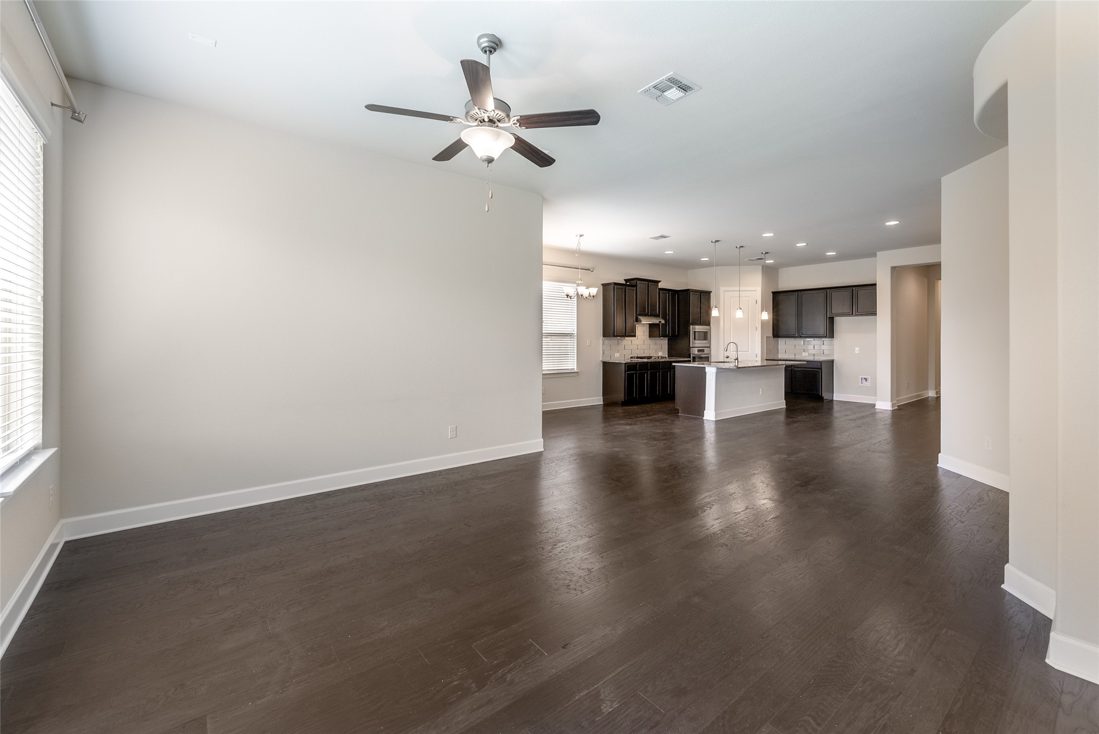 3043 Hidalgo Loop Round Rock, TX 78665 - Photo 7 of 34 Unfurnished living room featuring dark wood-type flooring, a ceiling fan, and recessed lighting