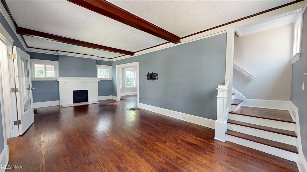 3174 Oak Road Cleveland, OH 44118 - Photo 5 of 33 Unfurnished living room with stairway, wood finished floors, beam ceiling, crown molding, and a fireplace with flush hearth