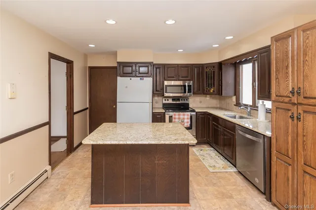 an open kitchen with kitchen island a sink stainless steel appliances and cabinets