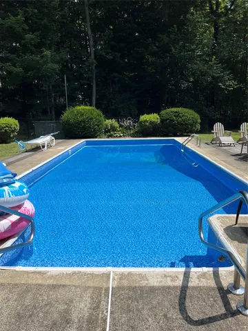 a view of swimming pool outdoor seating and green space