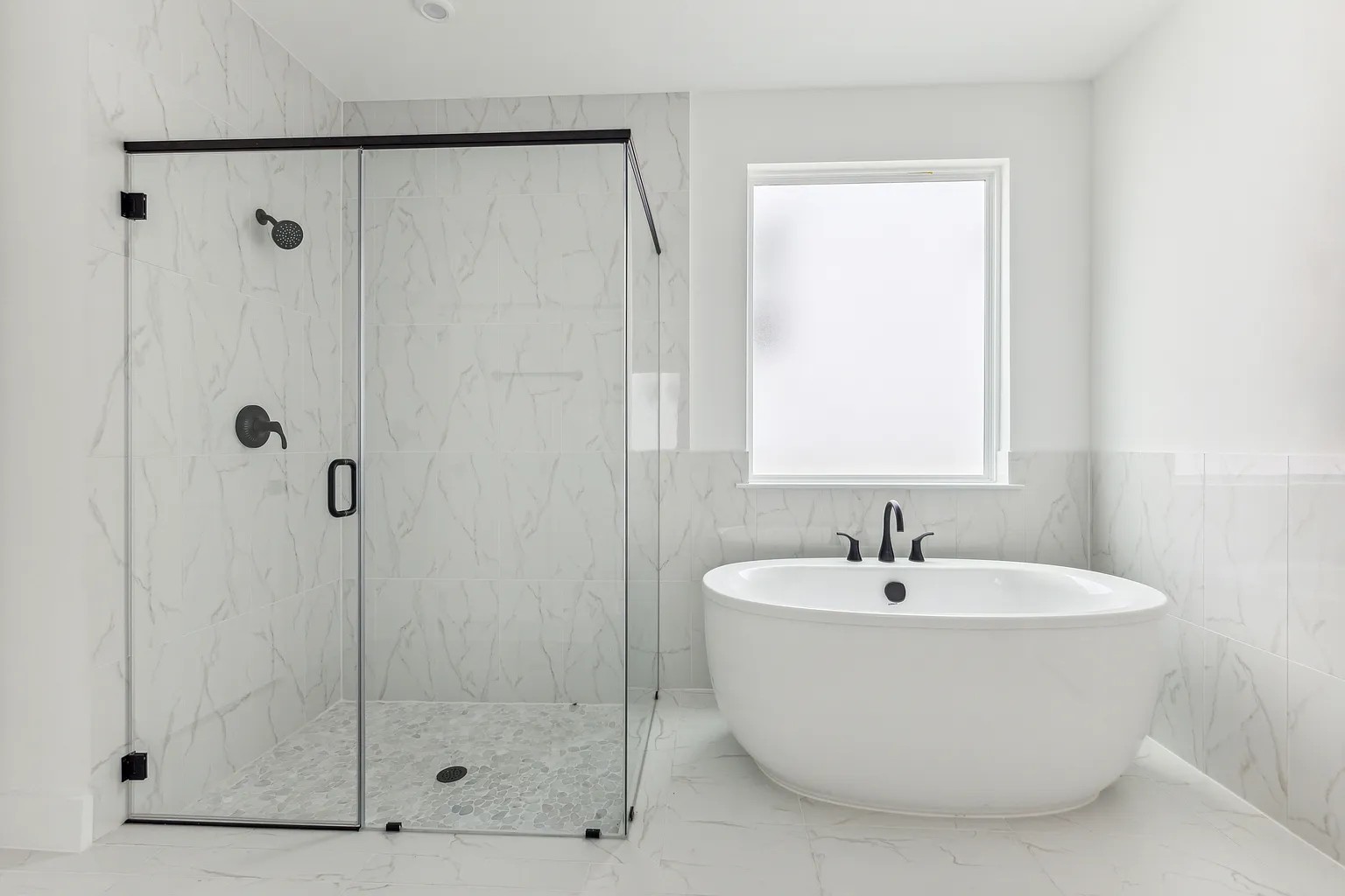 1909 Varese Path Leander, TX 78641 - Photo 19 of 40 Luxurious bathing options include a spacious glass-enclosed shower and a free-standing tub, all set on elegant tile flooring.