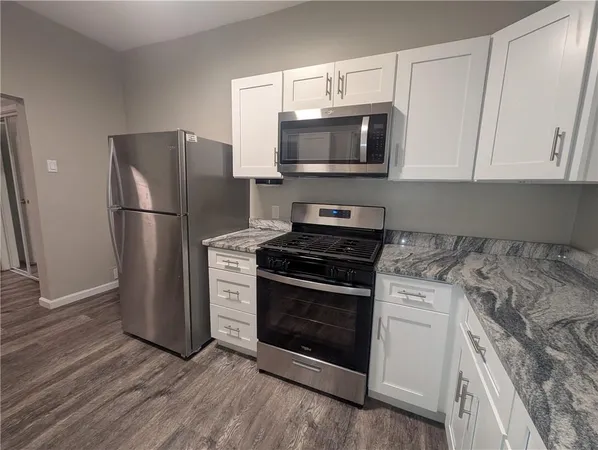 a kitchen with stainless steel appliances granite countertop a stove a sink and a microwave