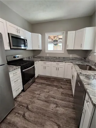 a kitchen with stainless steel appliances granite countertop a stove microwave and sink