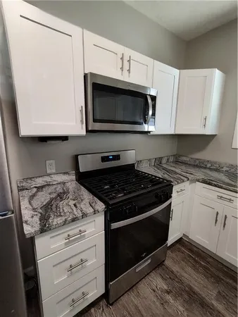 a kitchen with stainless steel appliances granite countertop a refrigerator a stove a sink and a microwave