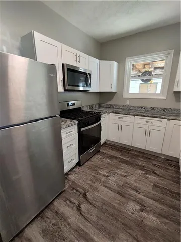 a kitchen with granite countertop a refrigerator and a sink
