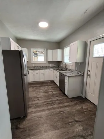 a large kitchen with granite countertop a stove and a sink