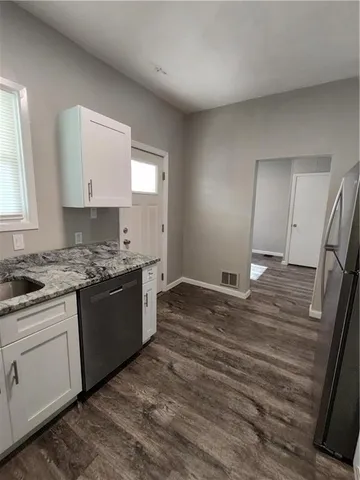 a kitchen with stainless steel appliances granite countertop a refrigerator and a stove