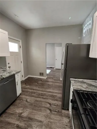 a kitchen with wooden floors and white appliances