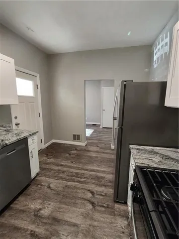 a kitchen with wooden floors and white appliances