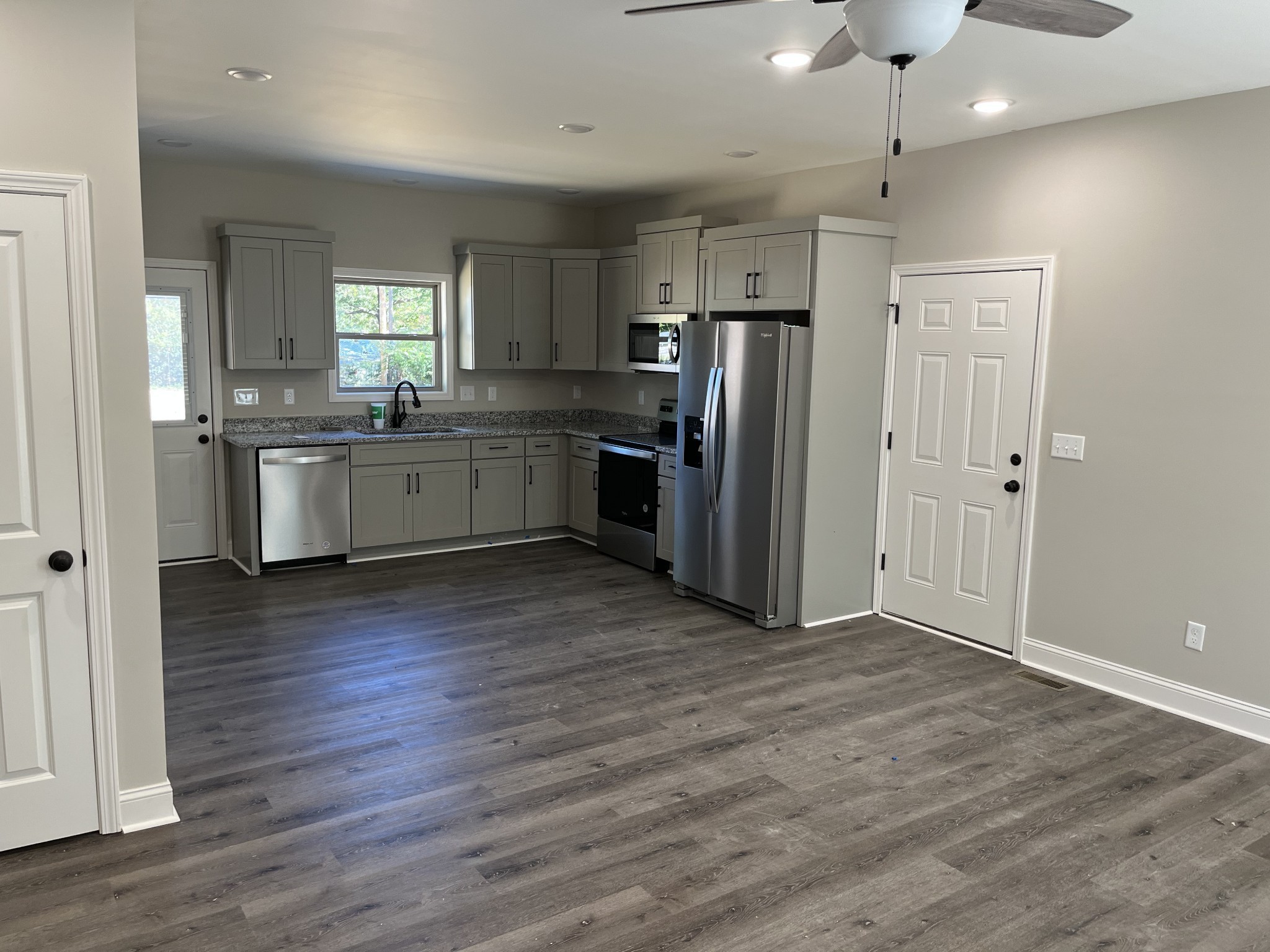 9970 West Green Cemetery Road Bon Aqua, TN 37025 - Photo 2 of 8 a large kitchen with a wooden floor and stainless steel appliances