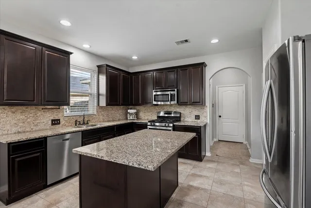 a kitchen with granite countertop stainless steel appliances and wooden cabinets