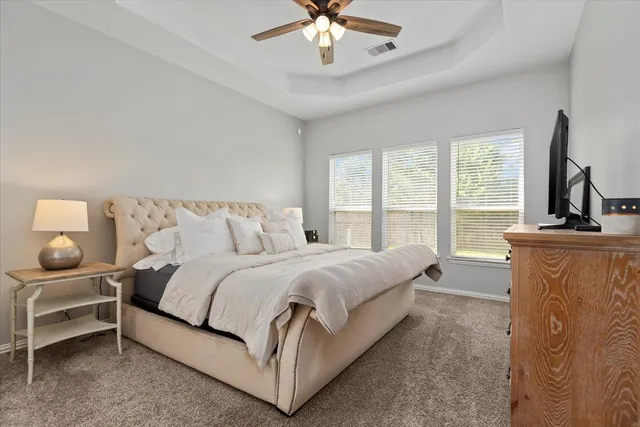 a spacious bedroom with a bed and a chandelier