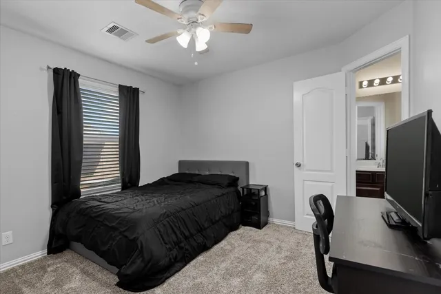 a bedroom with a bed tv and a chair