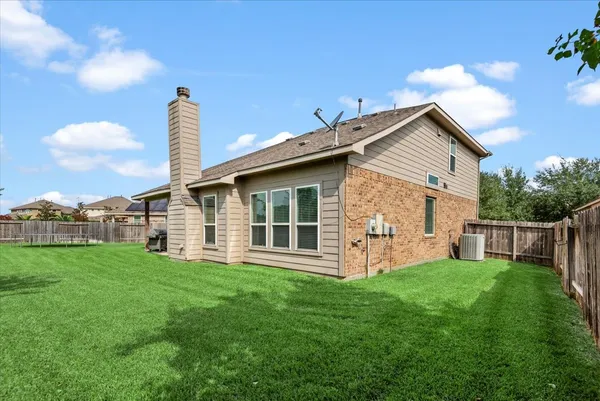 a view of a house with a yard and table with chairs