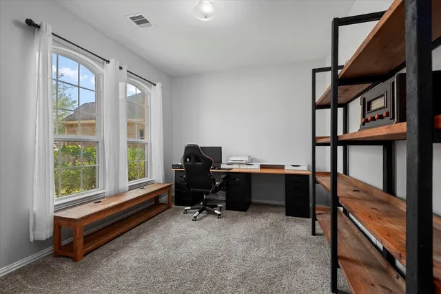 a view of a workspace with furniture and a window