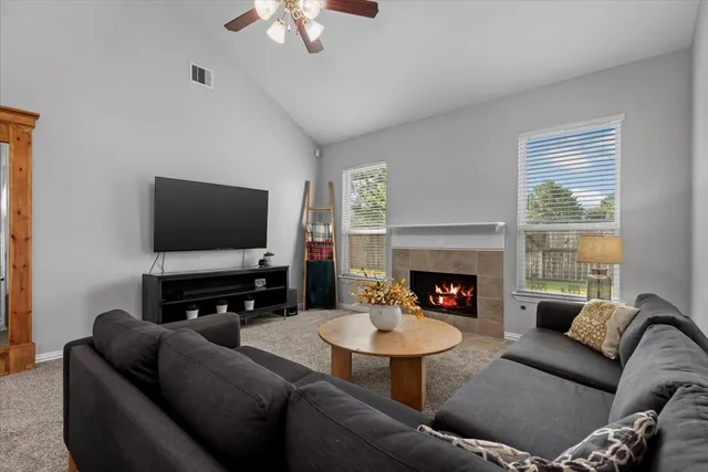a living room with furniture a fireplace and a flat screen tv