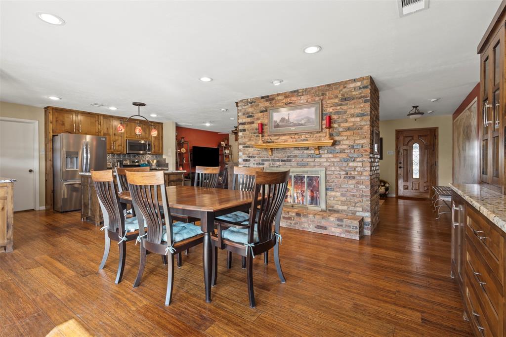 1009 West Interstate 20 Grand Prairie, TX 75052 - Photo 13 of 40 a dining room with furniture wooden floor a rug and a kitchen view