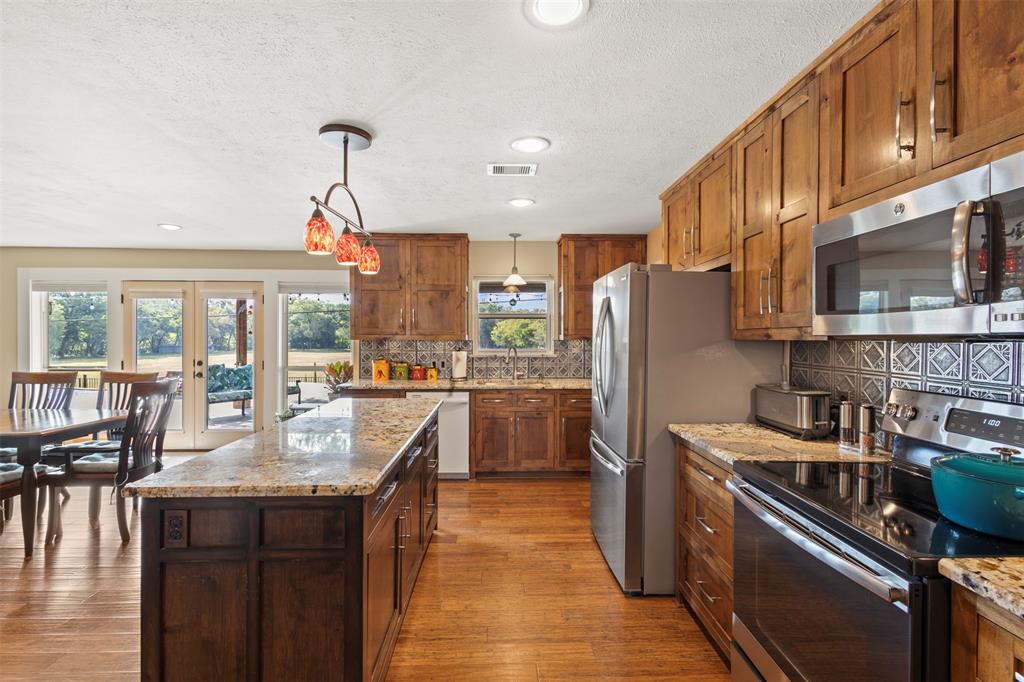 1009 West Interstate 20 Grand Prairie, TX 75052 - Photo 13 of 40 a kitchen with stainless steel appliances granite countertop a refrigerator a stove top oven a sink and dishwasher