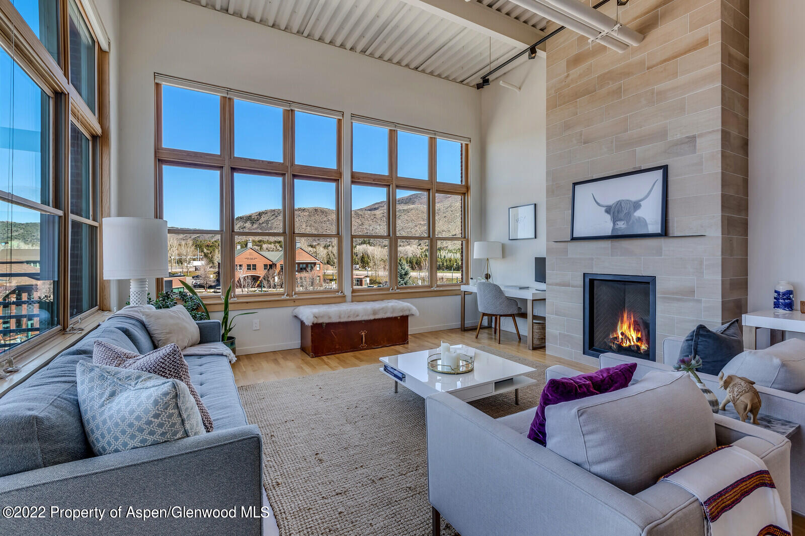 a living room with furniture fireplace and a large window