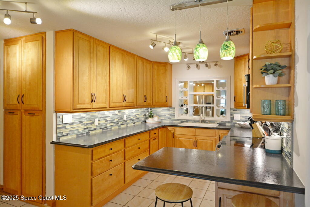 15 Hardee Circle South Rockledge, FL 32955 - Photo 13 of 44 a large kitchen with kitchen island granite countertop a stove a sink and dishwasher wooden cabinets with granite countertops