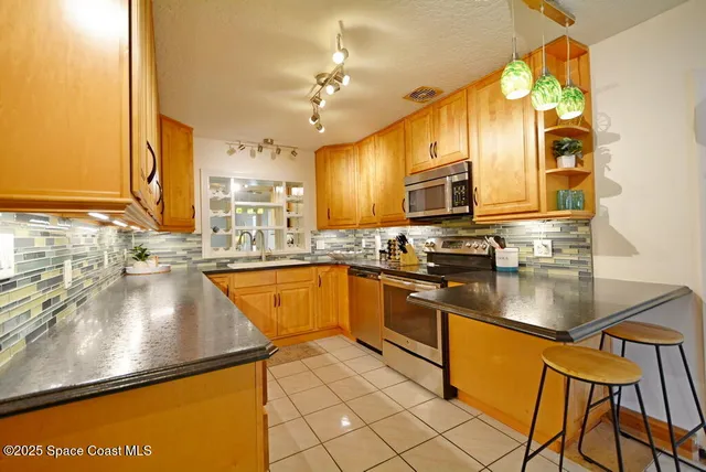 a kitchen with stainless steel appliances granite countertop a sink counter space and cabinets