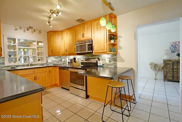 a kitchen with stainless steel appliances granite countertop a sink and a stove