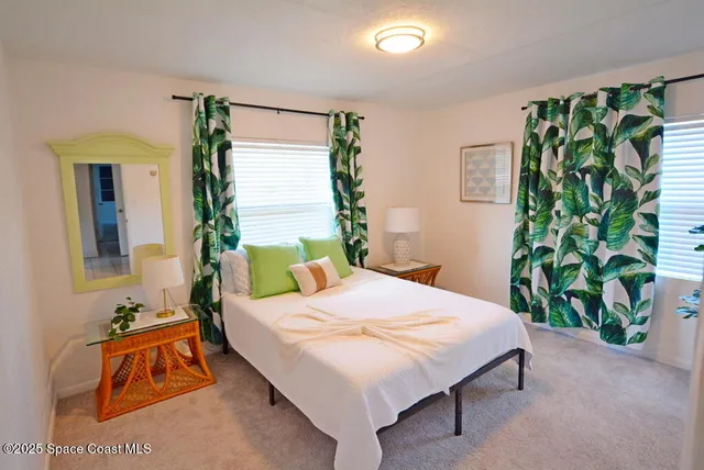 a bedroom with a bed mirror and a potted plant