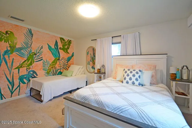 a bedroom with two beds and a painting on the wall