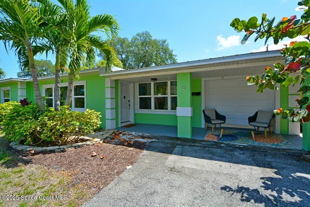 a view of a house with a yard and sitting area