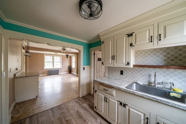 a hallway with stainless steel appliances granite countertop a sink a stove and a window