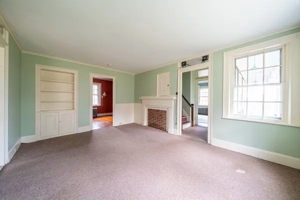 an empty room with windows and cabinet