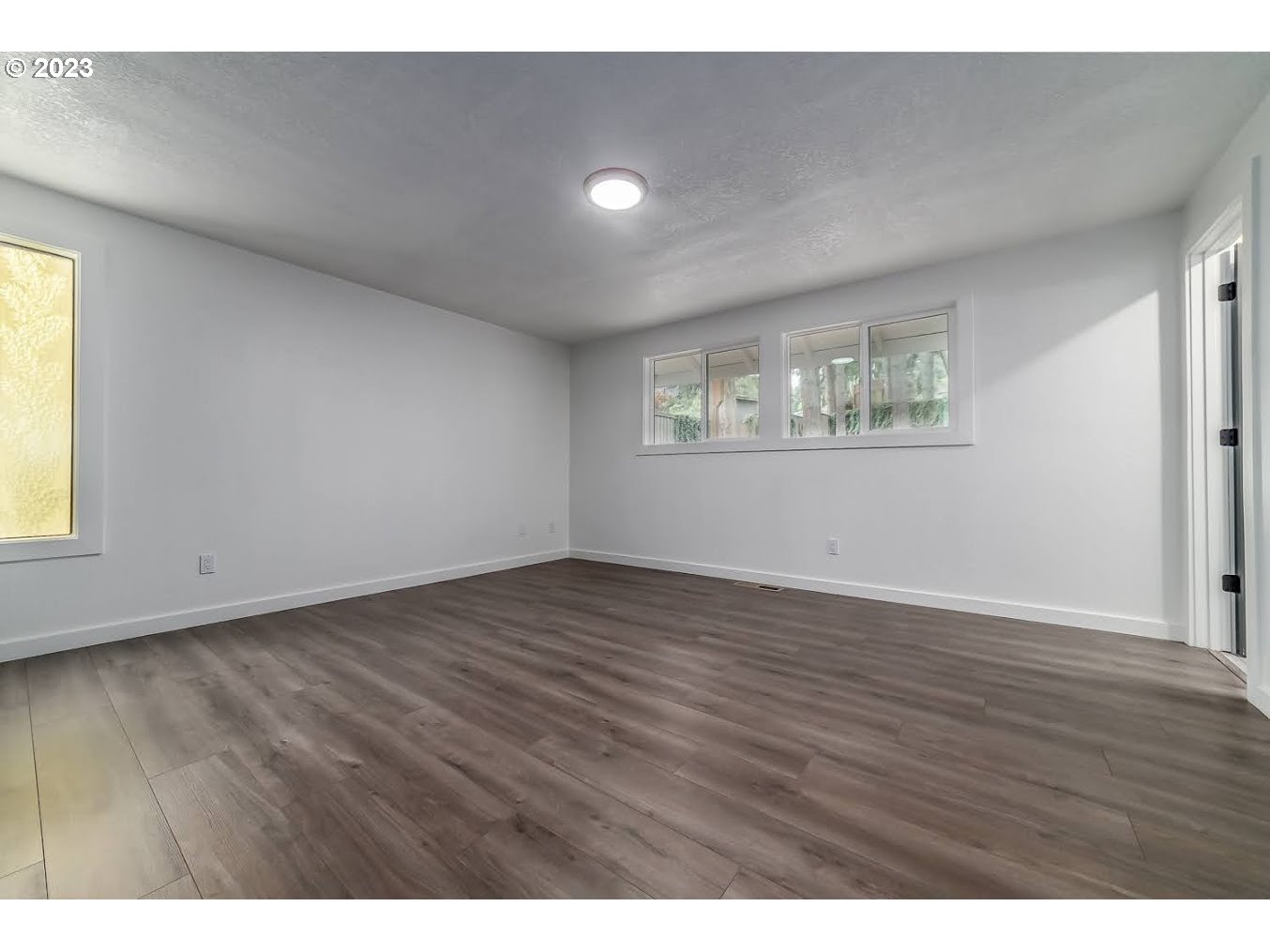 261 South 68th Place Springfield, OR 97478 - Photo 18 of 47 a view of an empty room with wooden floor and a window
