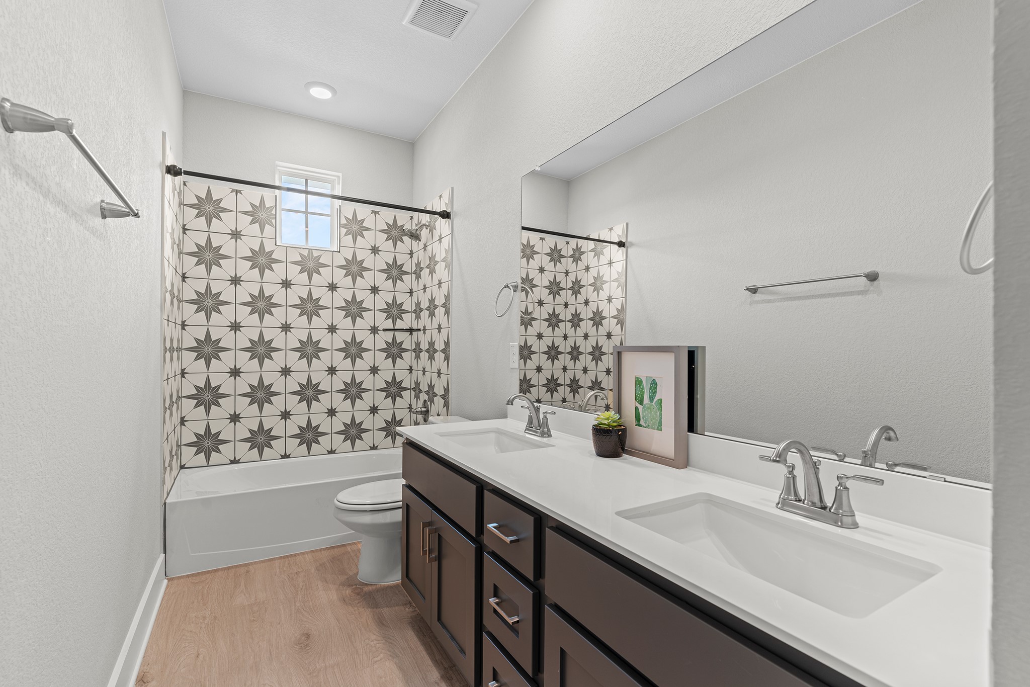2112 Tobiano Trace Georgetown, TX 78633 - Photo 35 of 40 Bathroom featuring light wood-style floors, shower / bathtub combination with curtain, double vanity, and a textured wall