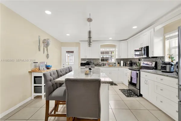 a kitchen with white cabinets and appliances