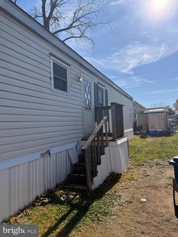 a view of a house with a yard and wooden fence