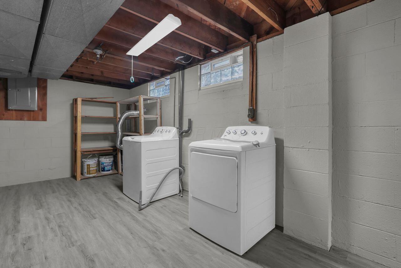 1535 Kenwick Road Columbus, OH 43209 - Photo 21 of 26 Basement laundry with washer, dryer, shelving, and glass block windows.